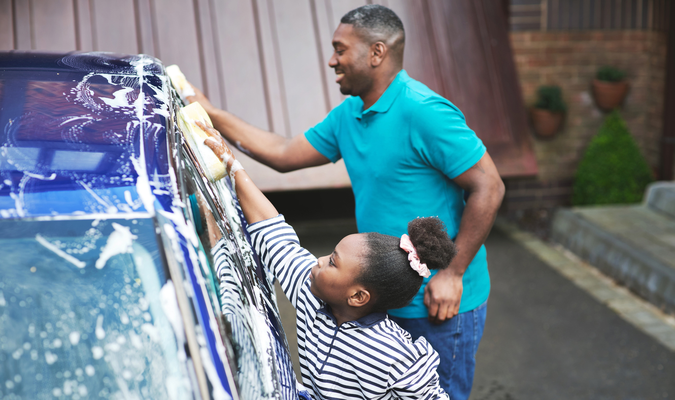Shot of a father and his daughter washing their car outside