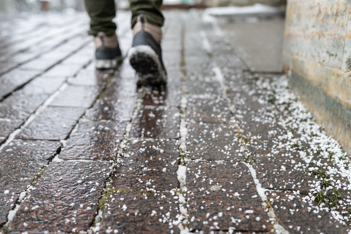 Person walking on salted icy sidewalk.