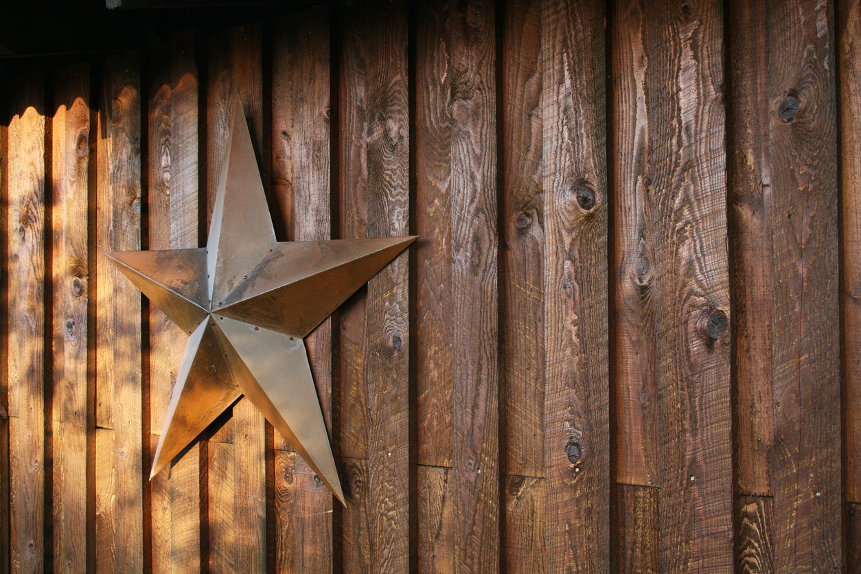 Outdoor decorative tin metal star hanging on wood background