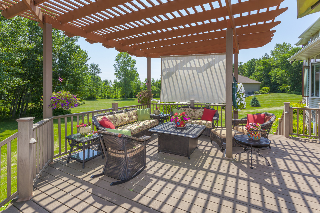 Outdoor pergola with sun shade and patio furniture. .