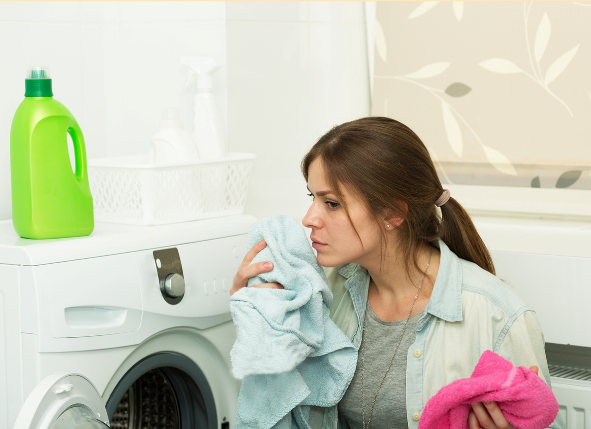 Woman smelling clothes in laundry room.