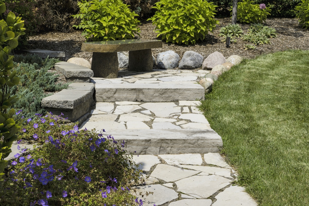 An attractive home landscape with a stone path and steps.