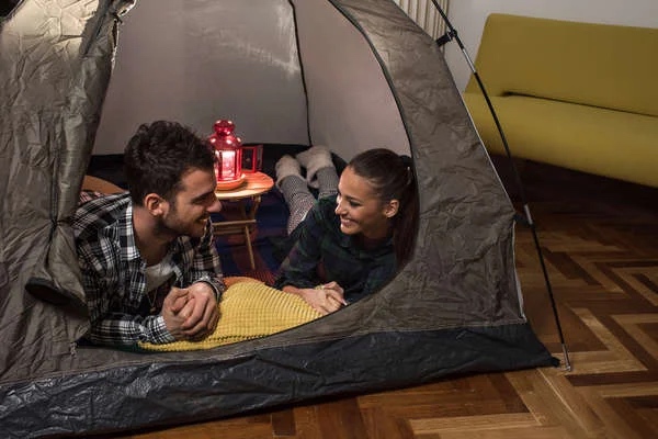 man and woman camp in living room during power outagew