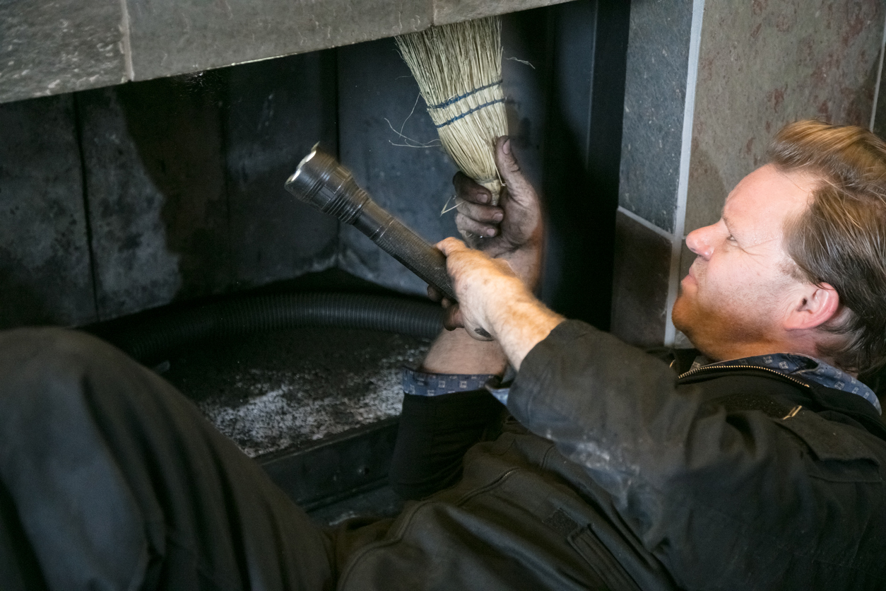 Chimney Sweep cleaning fireplace inside of home