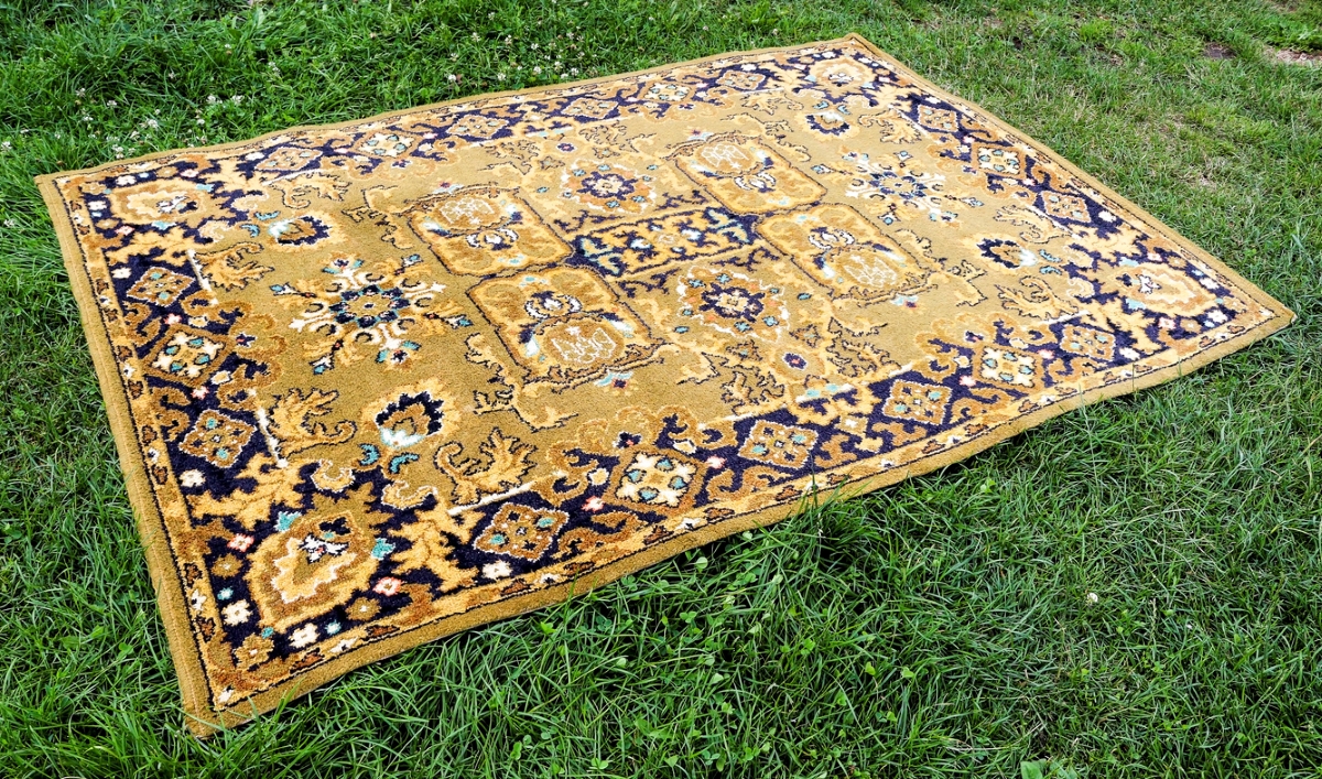 Persian rug laid on green grass.