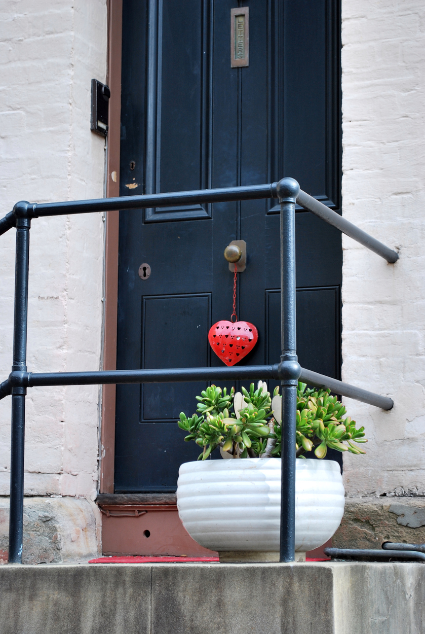 Cosy home entrance porch with a plant and a heart on a door knob