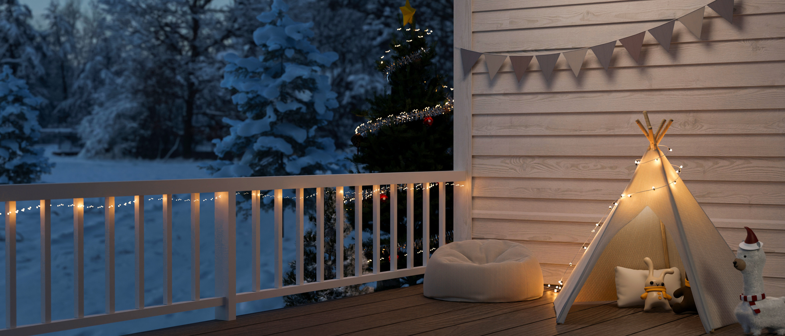 White porch rail and siding, dog bed, and child-size tipi decorated with white string lights on porch.