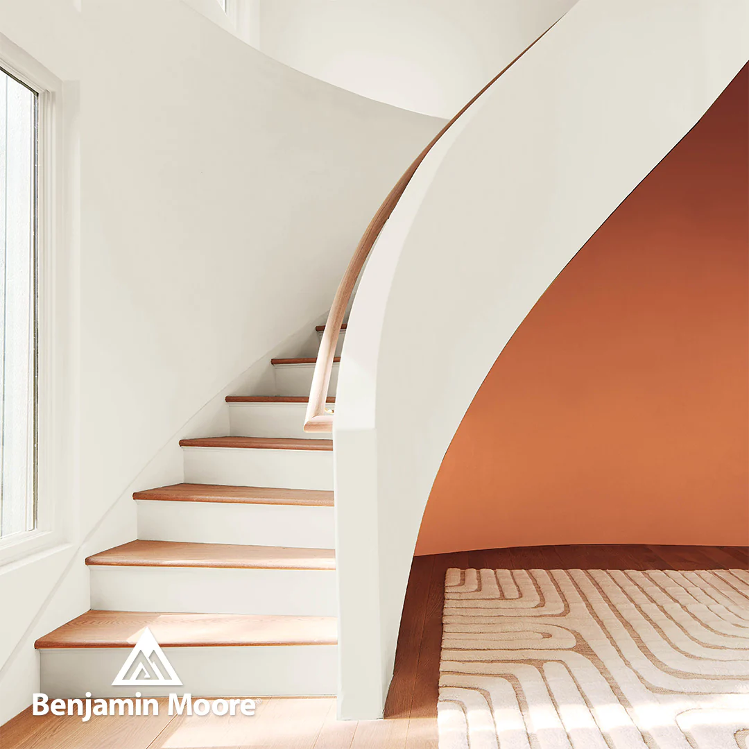 A-staircase-painted-with-White-Dove-by-Benjamin-Moore-is-offset-by-an-orange-accent-wall.