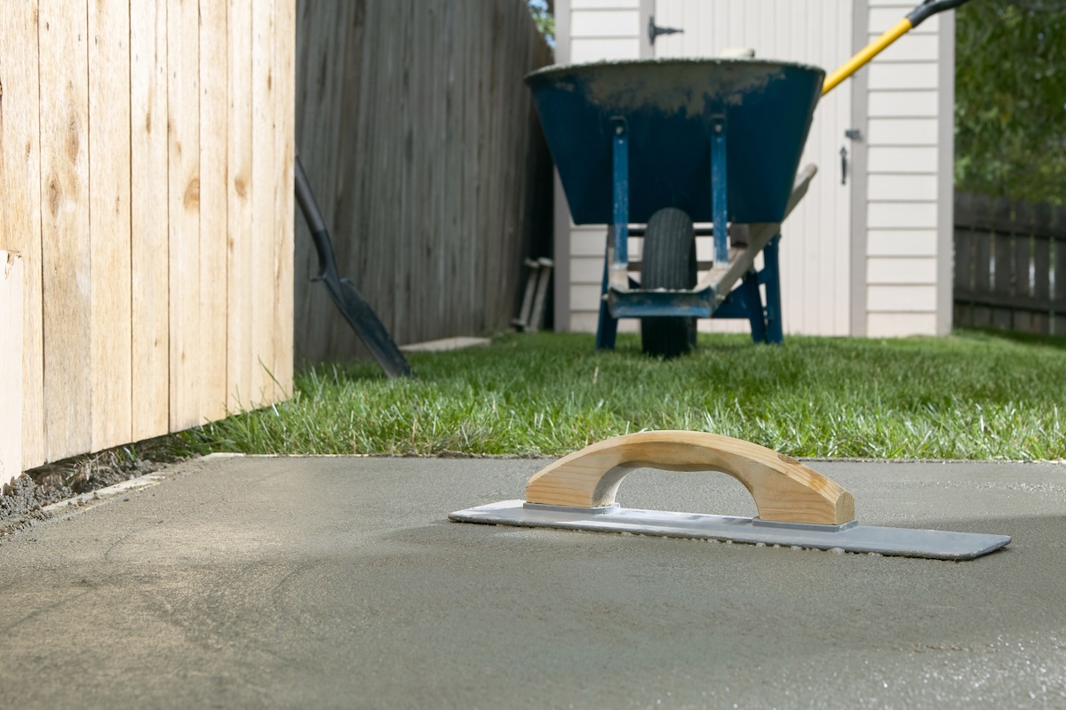 A smooth DIY concrete pad in a backyard.