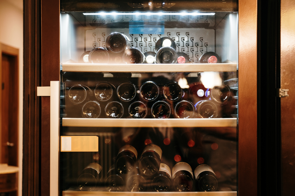 A wine refrigerator with wine bottles inside.