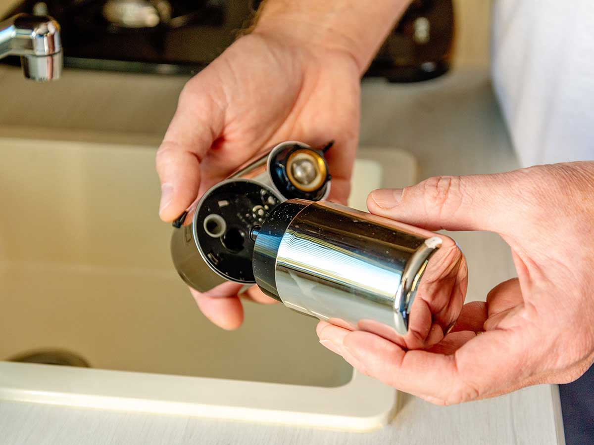 A person opening the Brita Complete water faucet filter to show its durable internal construction.