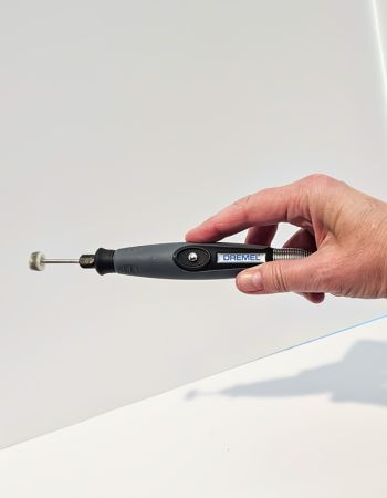 Person holding Dremel 4300 in front of white background