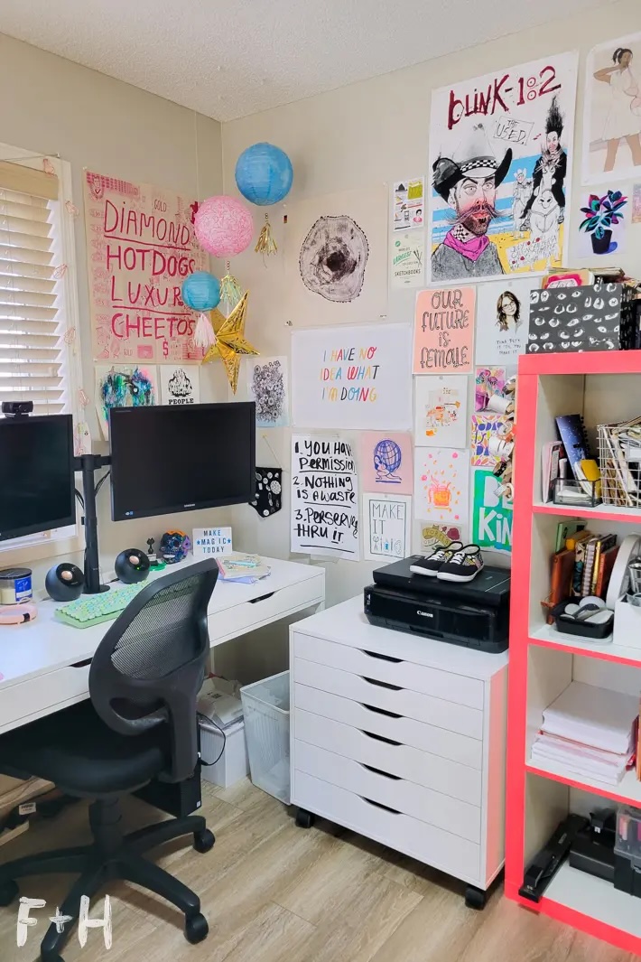 Small art studio with colorful personal art displayed on walls.