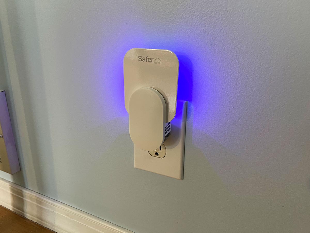 The Safer Home Indoor Fly Trap glowing blue while plugged into a wall outlet during testing.