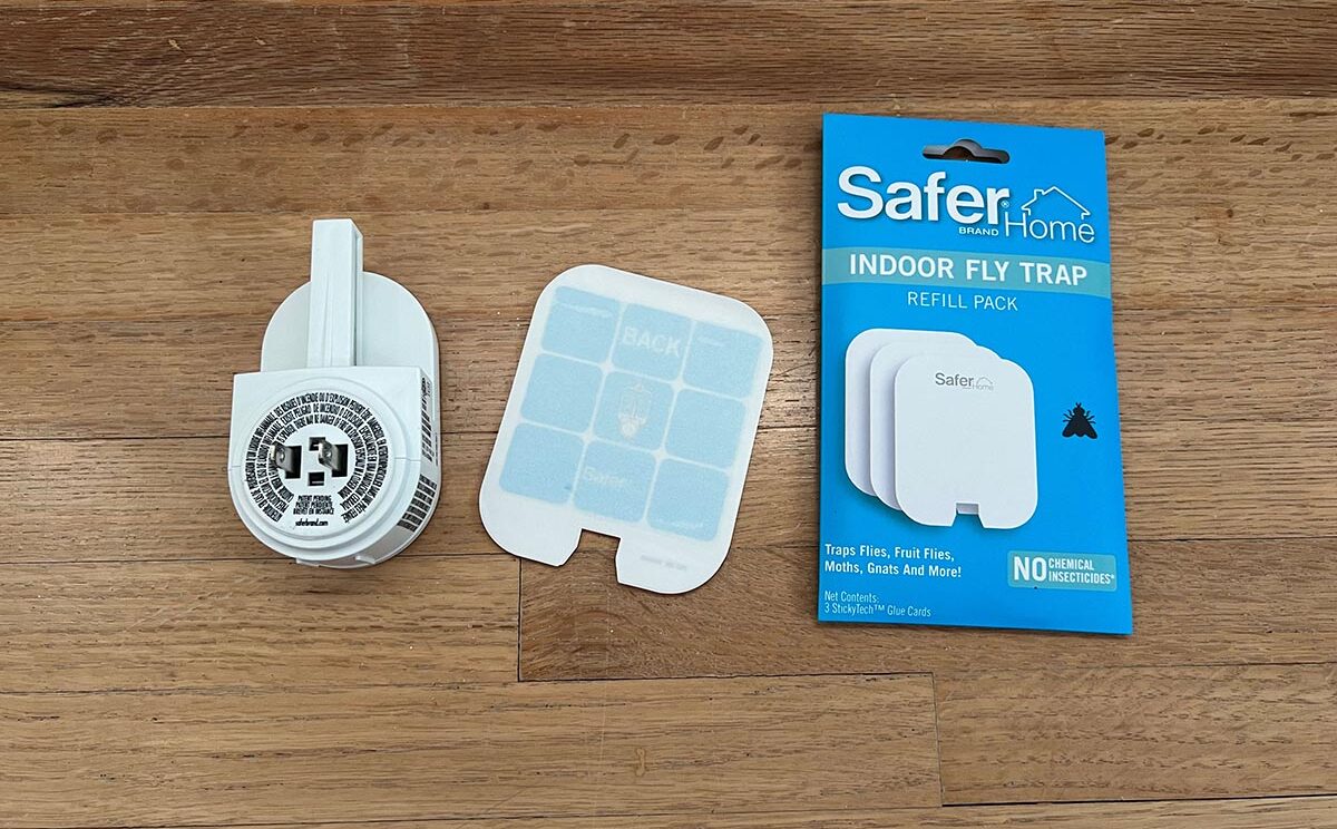 The Safer Home Indoor Fly Trap set out on a wood floor in its individual parts with its packaging before testing.