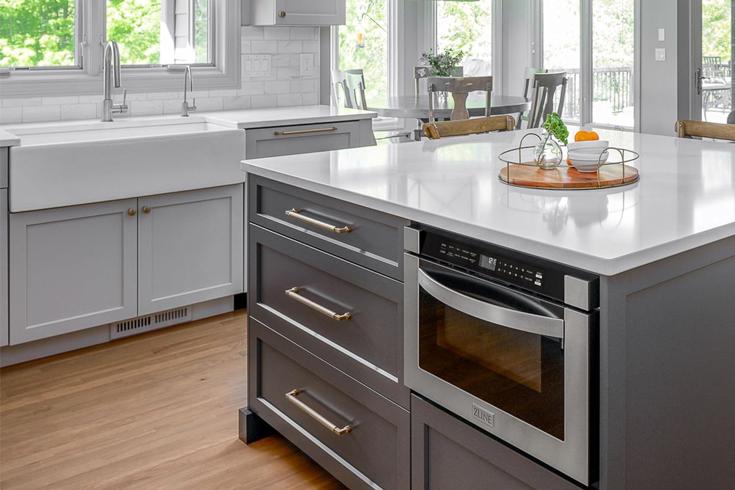 A microwave drawer installed under a kitchen island counter in a large and modern kitchen.