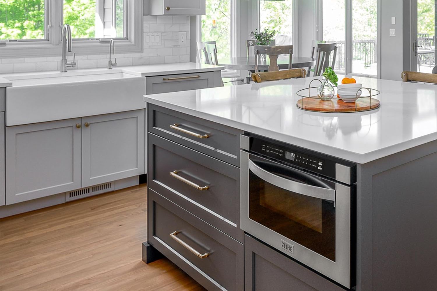 A microwave drawer installed under a kitchen island counter in a large and modern kitchen.