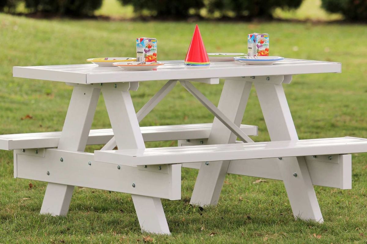The Dura-Trel 6-Foot White Vinyl Patio Picnic Table set up on a lawn and decorated with birthday decor.