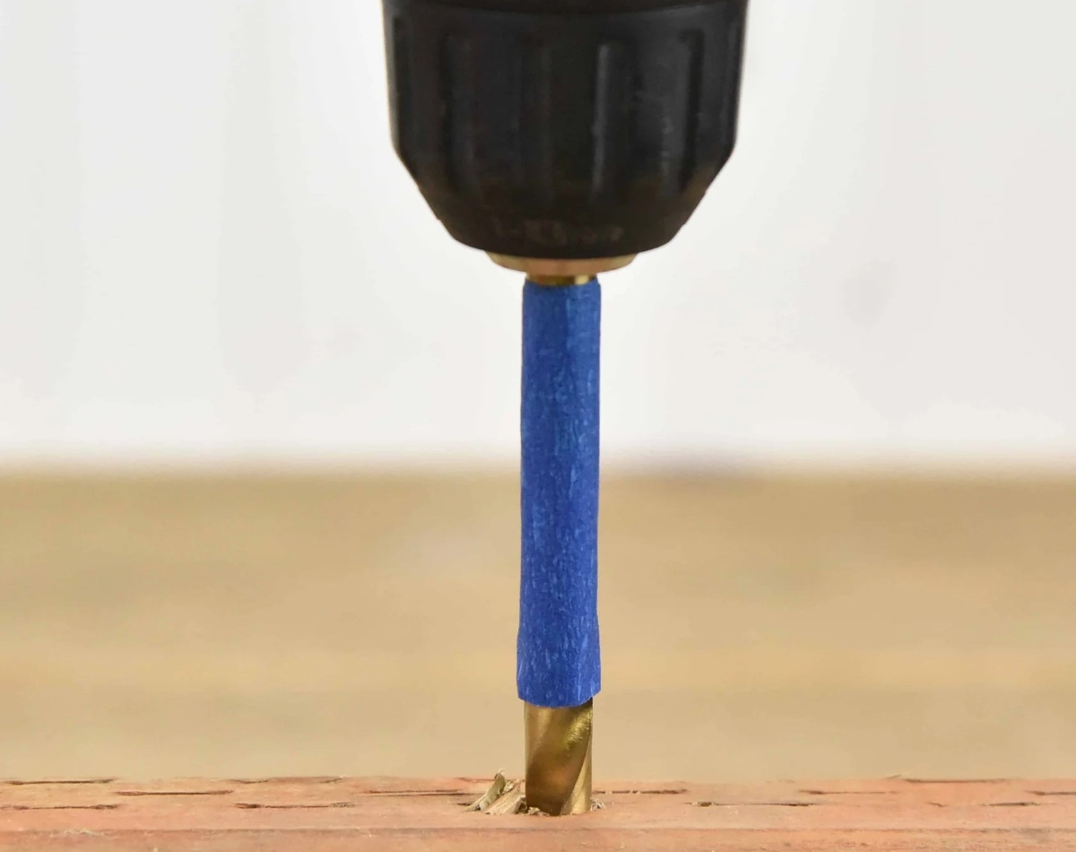 Close up of drill with blue tape.
