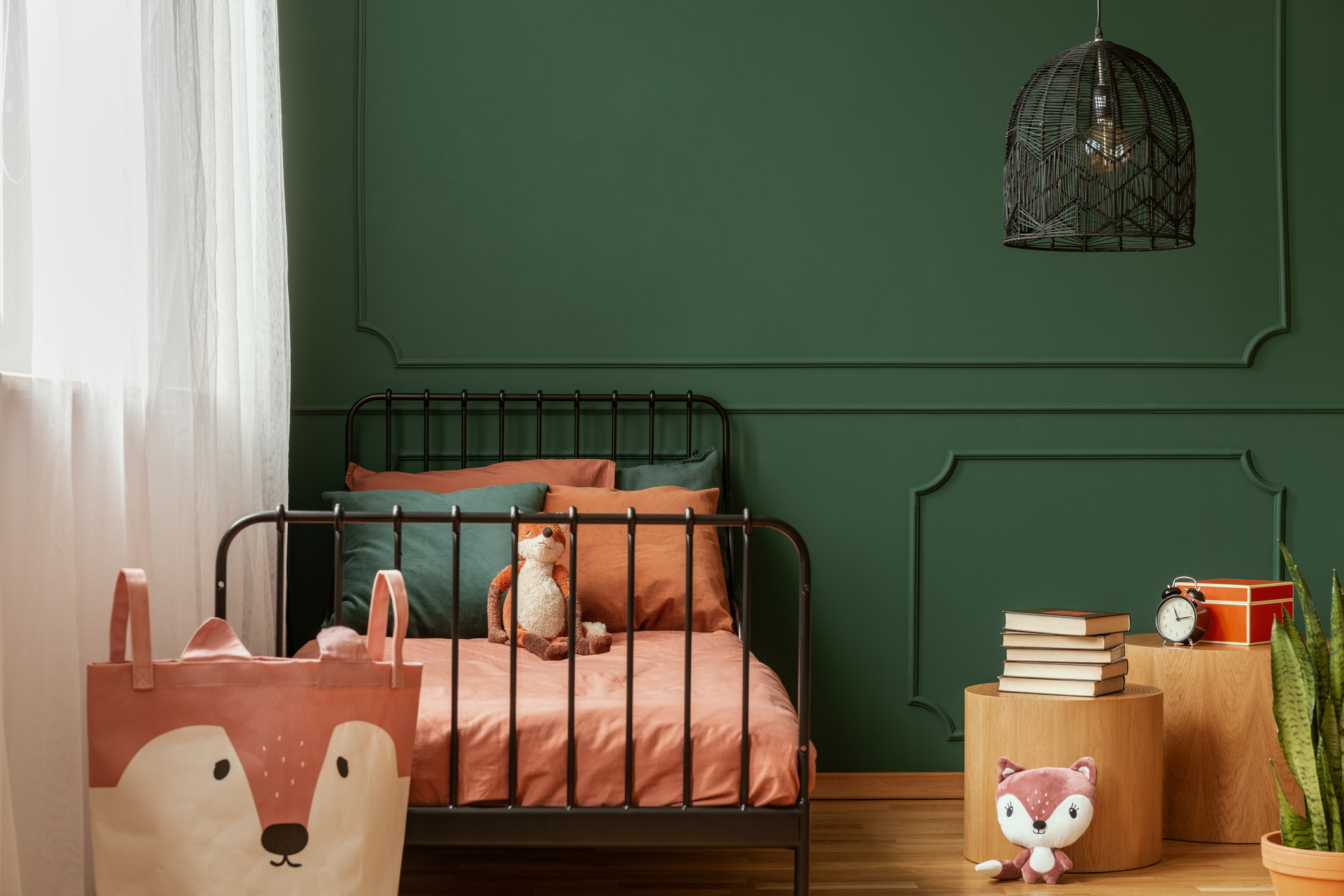 Child's bedroom with emerald green wall paint and salmon colored twin bed.