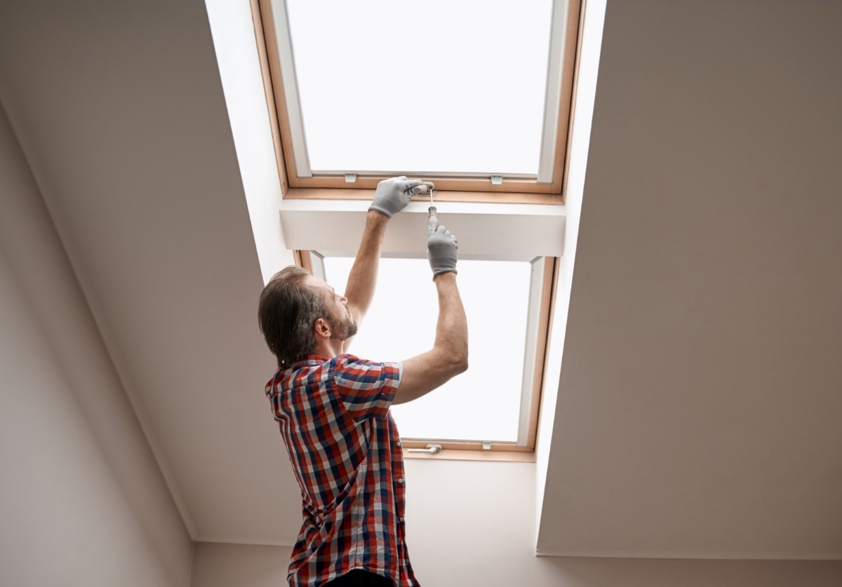 Man installing skylight in ceiling.