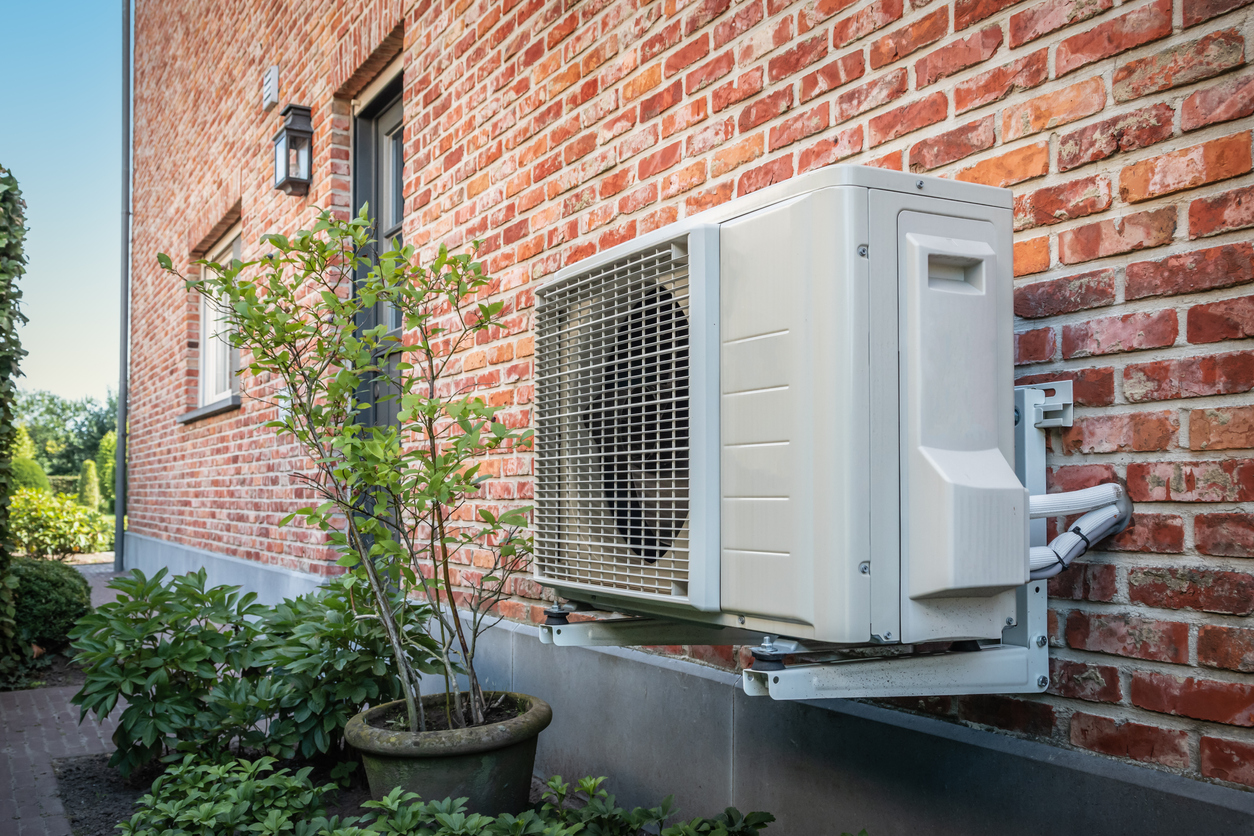 Heat pump and energy system perched outside brick home