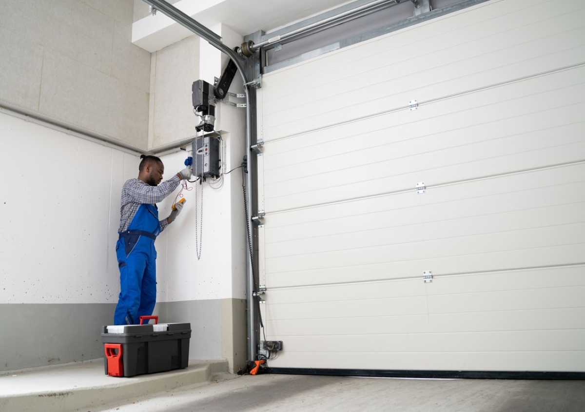 Professional repair man fixing garage door spring.