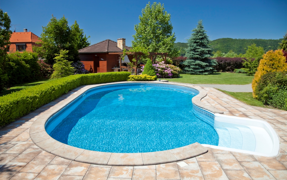 View of round in-ground pool on sunny day.