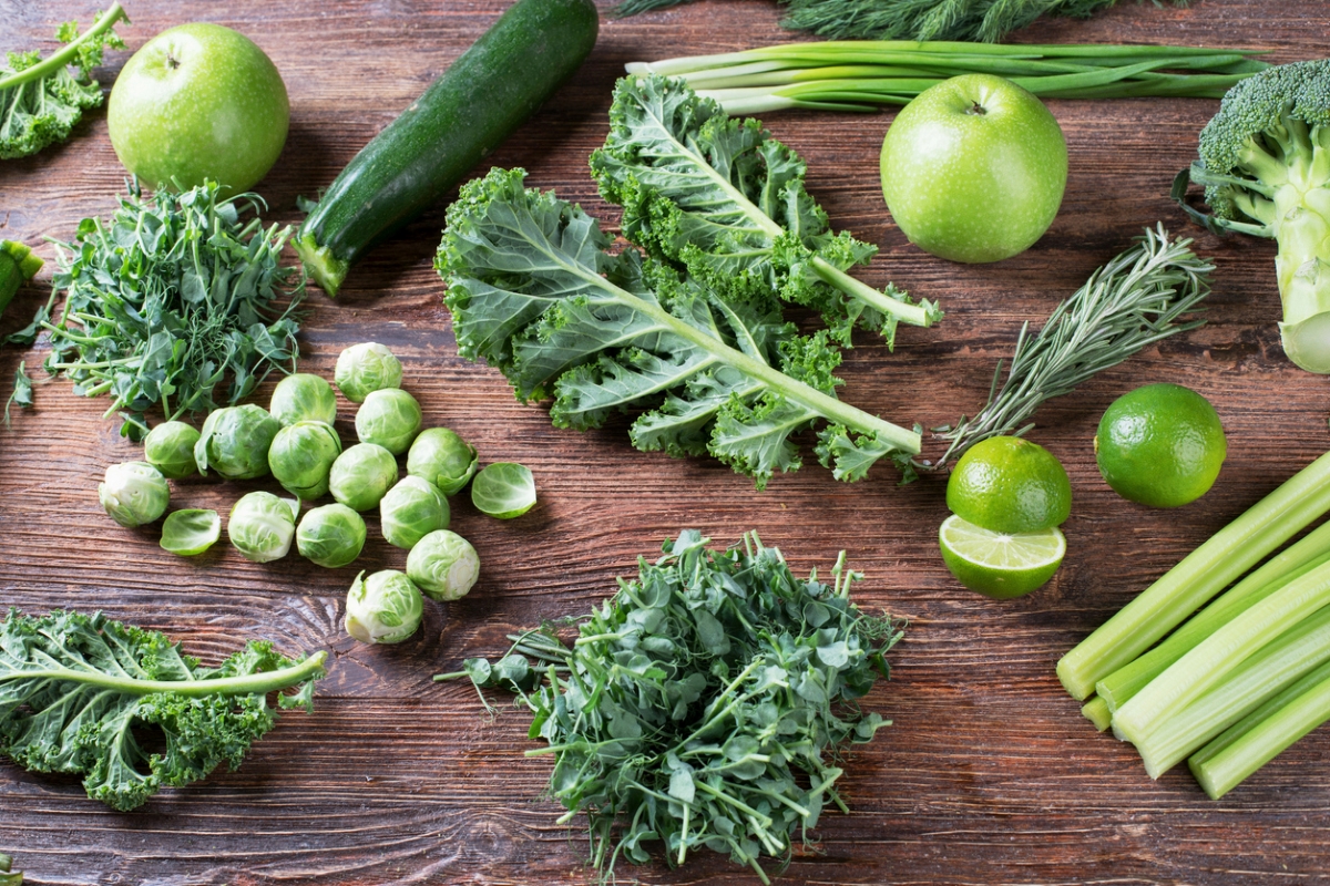 Fresh green vegetables on wooden background.