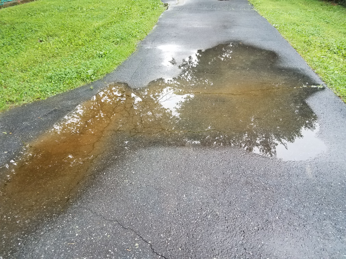 Paved driveway flooded with water.