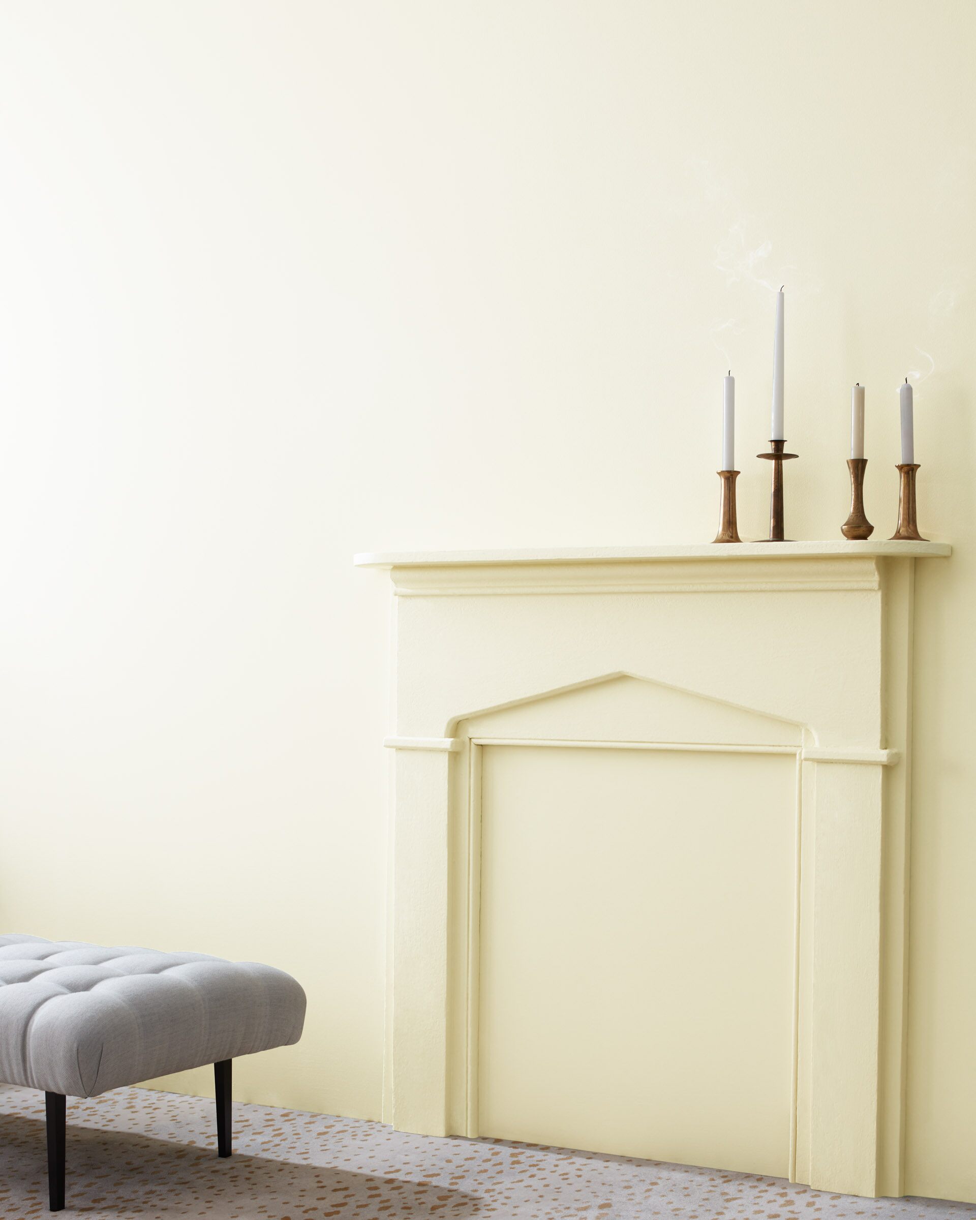 Wall with mantle and candle sticks painted in Cloud White by Benjamin Moore.