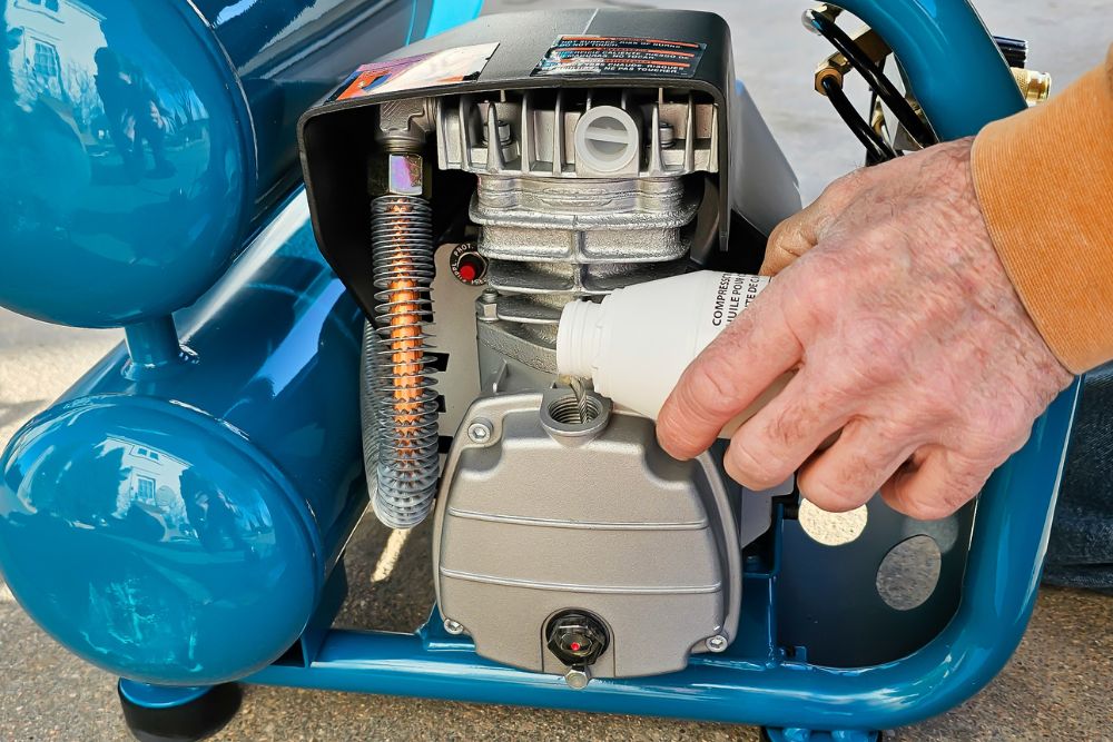A person adding oil to the Makita MAC2400 air compressor during testing.