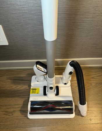 The docking station and included accessories of the Levoit LVAC-200 Cordless Vacuum on a hard floor surface during testing.