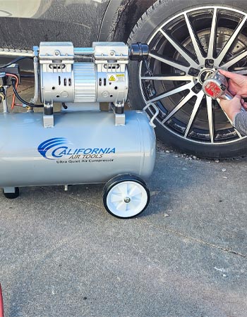 A person using the California Air Tools 8010 Ultra Quiet Air Compressor with an impact wrench during testing.