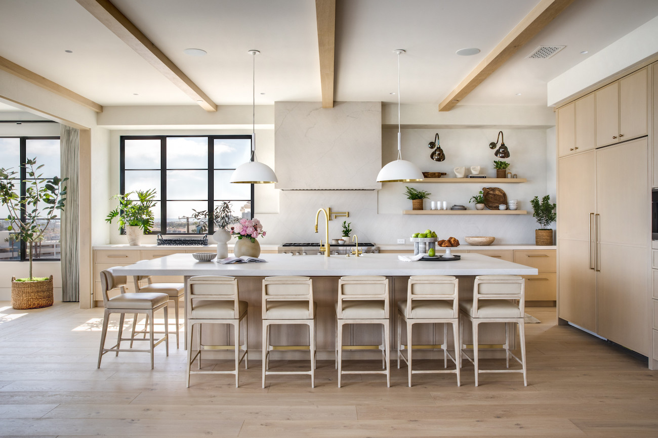A warm beige kitchen is airy and light with wood beams and natural elements.
