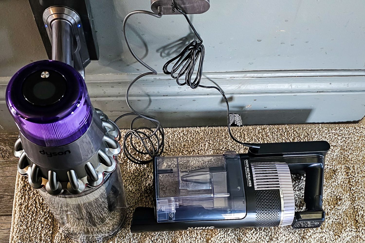 Dyson vs Shark cordless vacuum batteries plugged into a wall outlet to charge during testing.