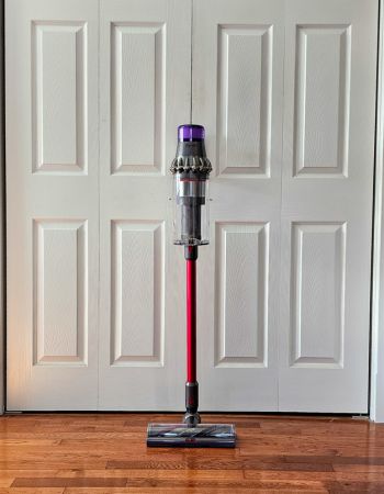 The Shark Stratos cordless vacuum leaning against closet doors before head-to-head testing of Dyson vs Shark.