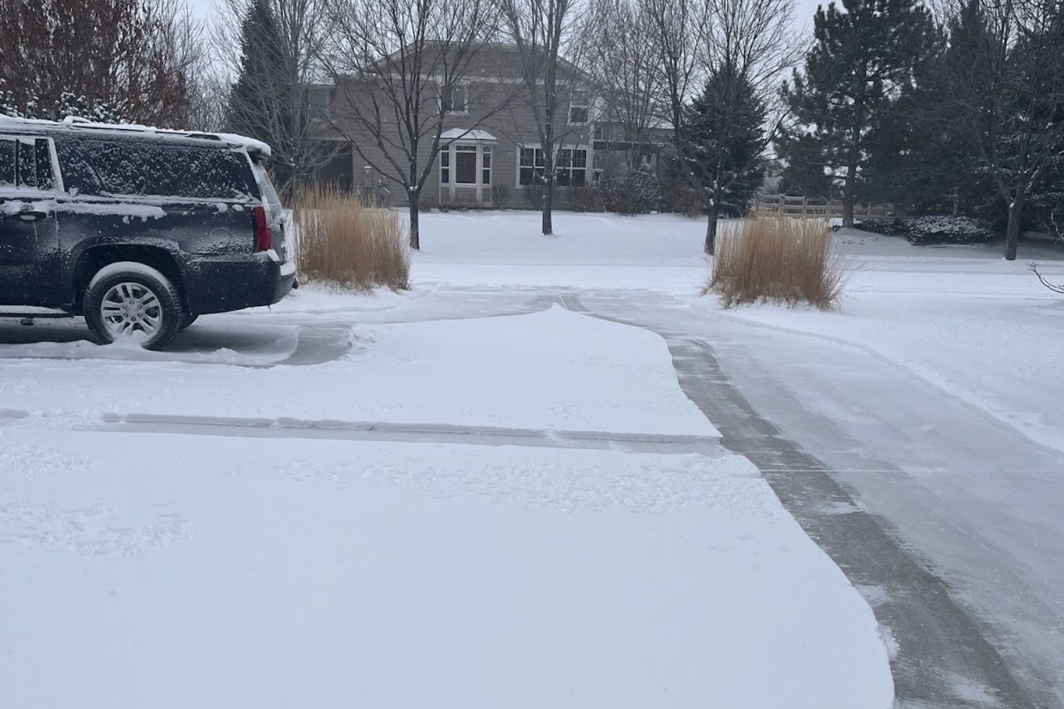 A driveway and walkway partially cleared using the Ego lightweight snow blower.