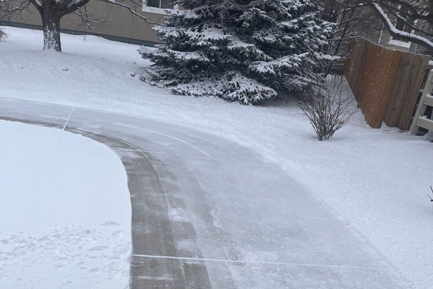 A wide curve of sidewalk cleared of snow using the Ego Lightweight Snow Blower.
