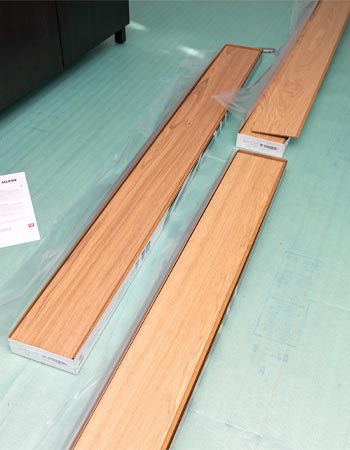 A few planks of Flooret engineered hardwood flooring on top of a subfloor before installation.