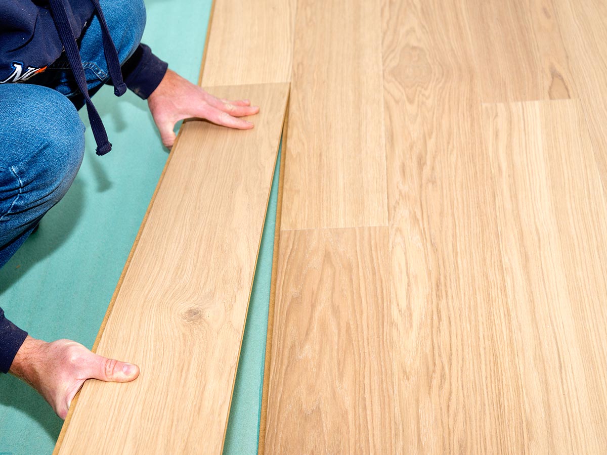 A person installing Flooret flooring using their click-lock system.