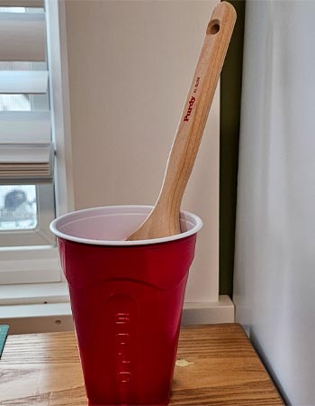 The Purdy 2-inch XL Glide Paint Brush in a red plastic cup.