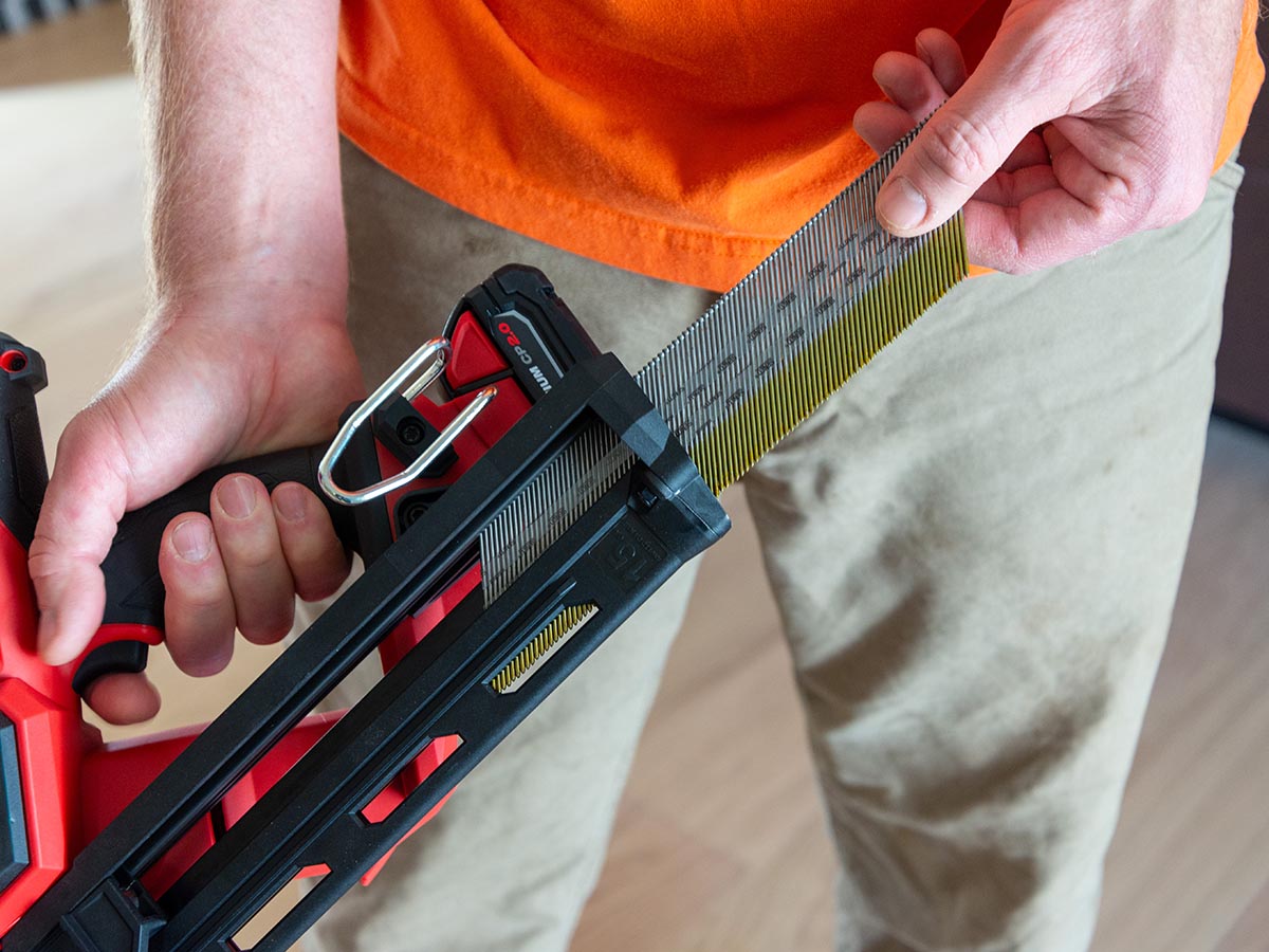 A person inserting Milwaukee 15-Gauge Finish Nailer's magazine before testing.