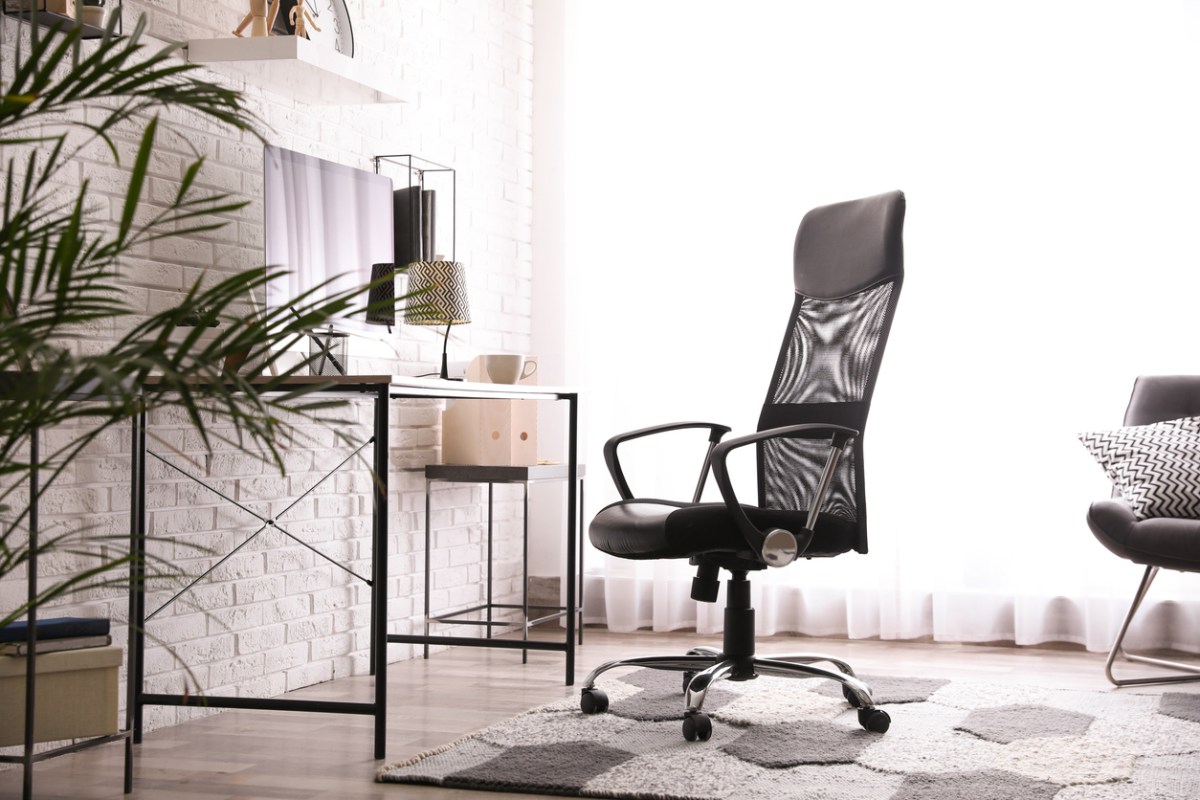 One of the best available big and tall office chairs on a patterned rug in a bright and airy home office.