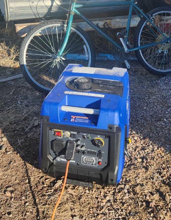 The Westinghouse iGen4500 portable inverter generator on mulch with a cord running from it during testing.