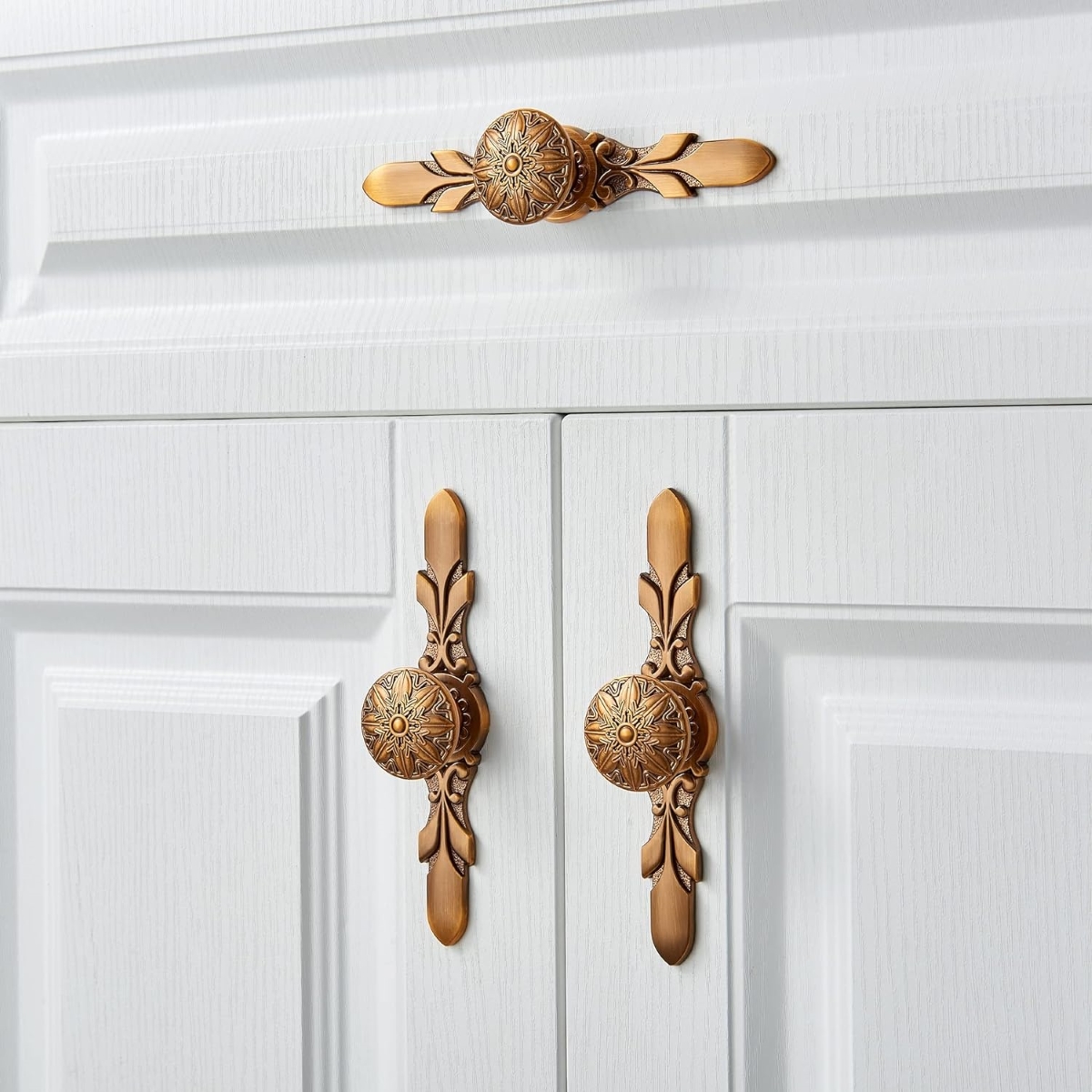 Copper antique hardware on white cabinets.