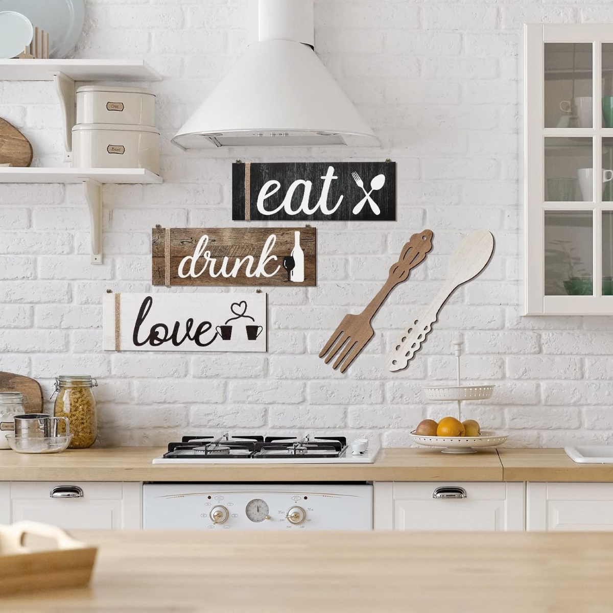 White kitchen with three large word signs on wall.