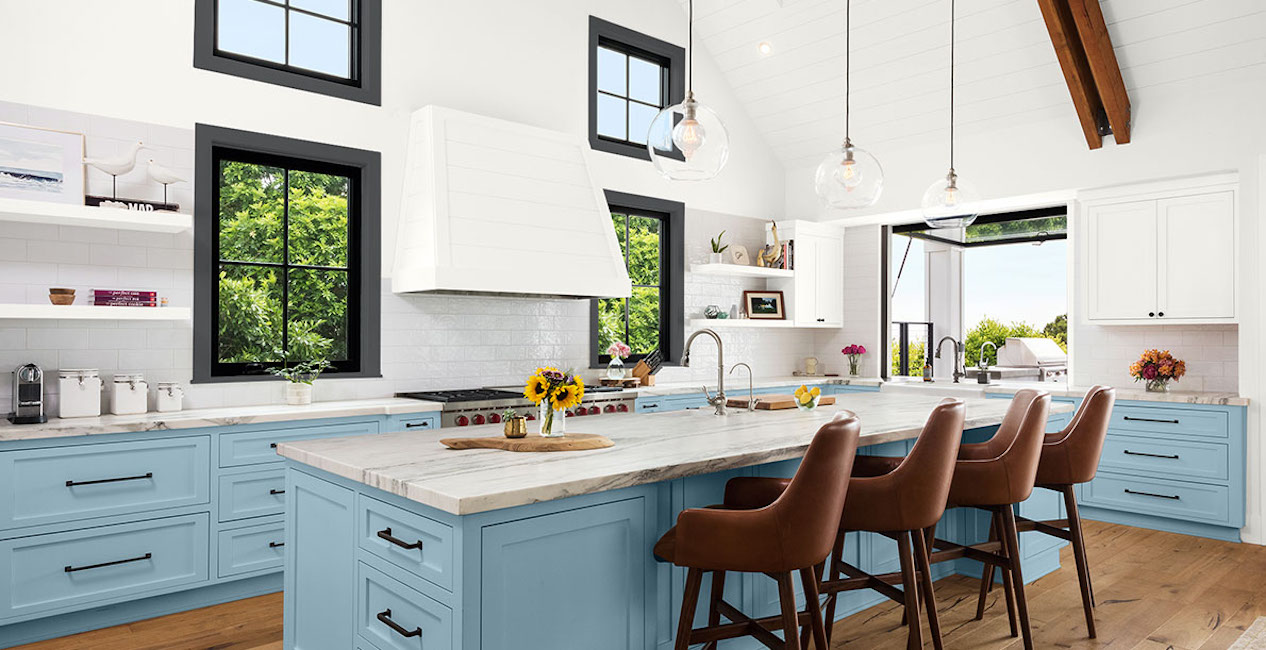 An airy kitchen has light blue cabinets and brown accents.