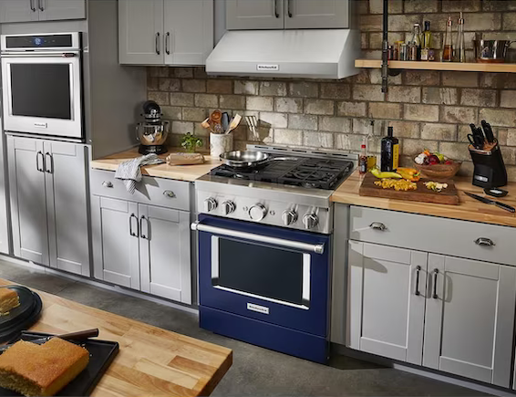 A KitchenAid blue stove is centered in a greige kitchen.