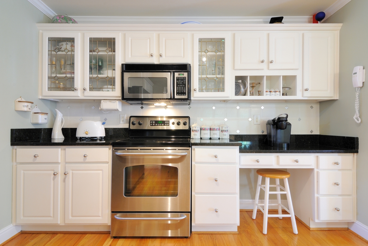White kitchen with microwave over stove.